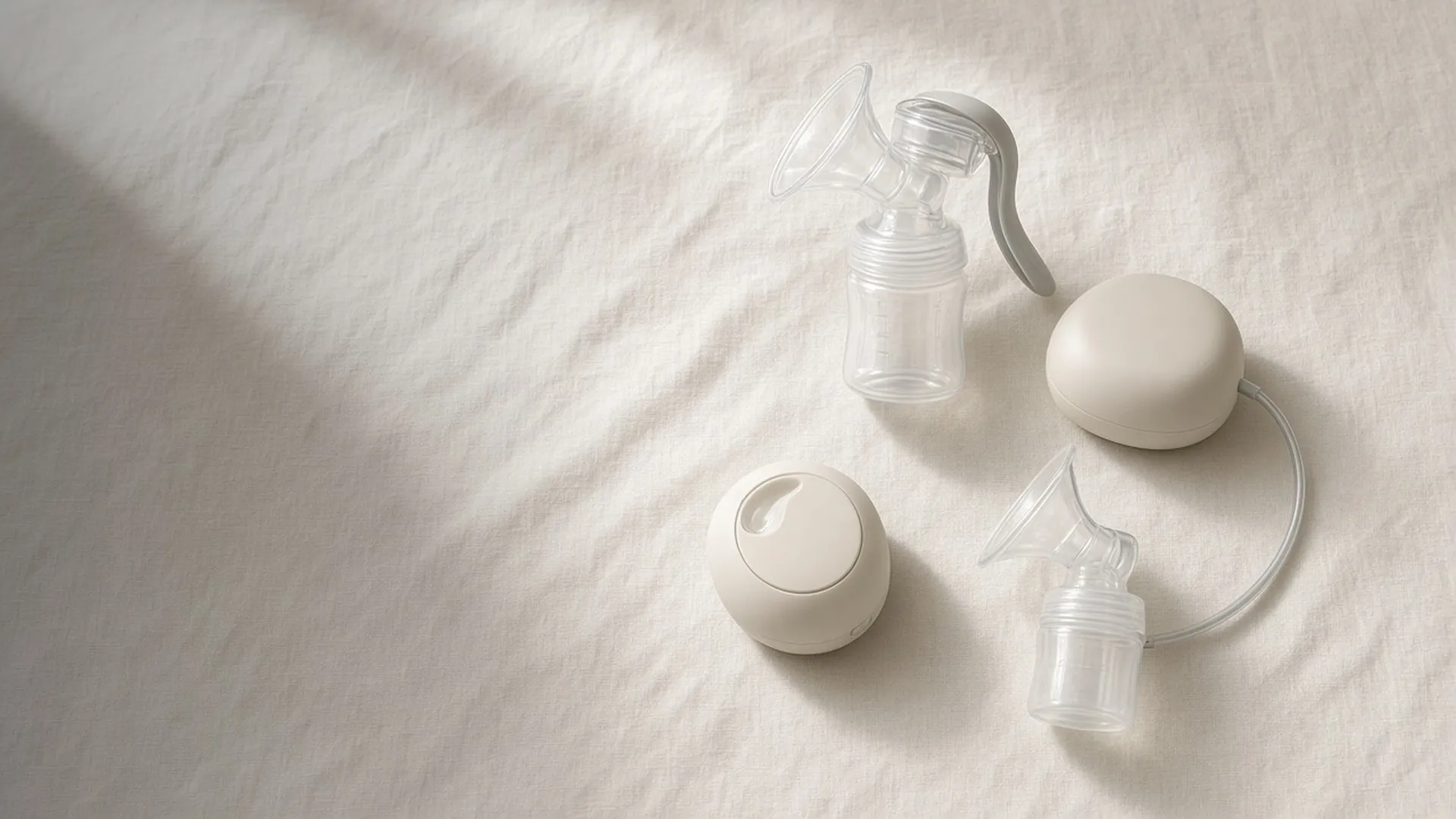 A manual pump, an electric pump, and a wearable cup on linen