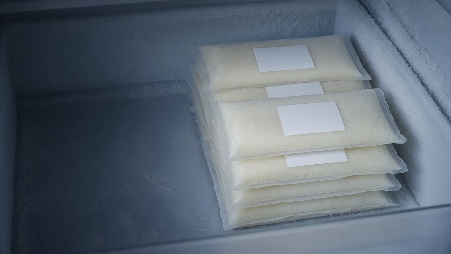 Frozen milk storage bags stacked in a freezer drawer