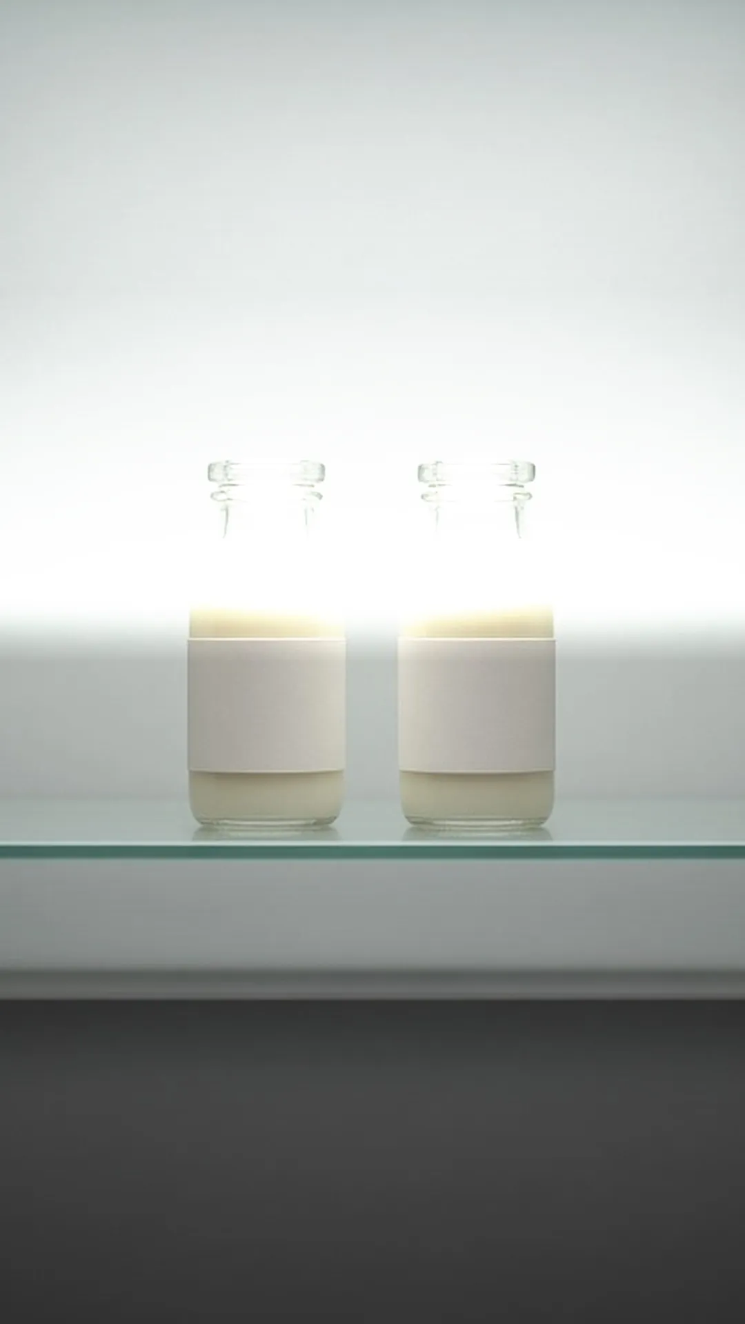 Bottles and storage bags of milk on a refrigerator shelf